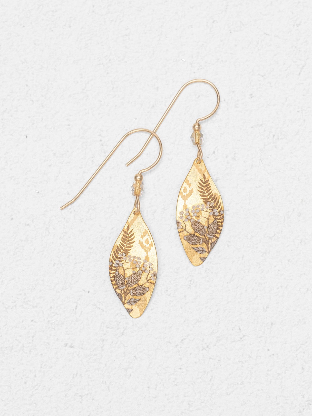Gold marquise shaped drop earrings on white background