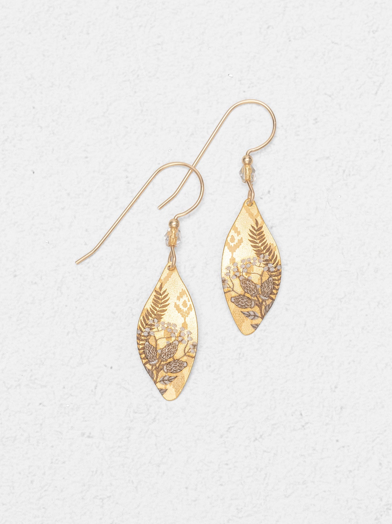 Gold marquise shaped drop earrings on white background