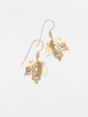 Gold leaf-shaped earrings on a light gray background