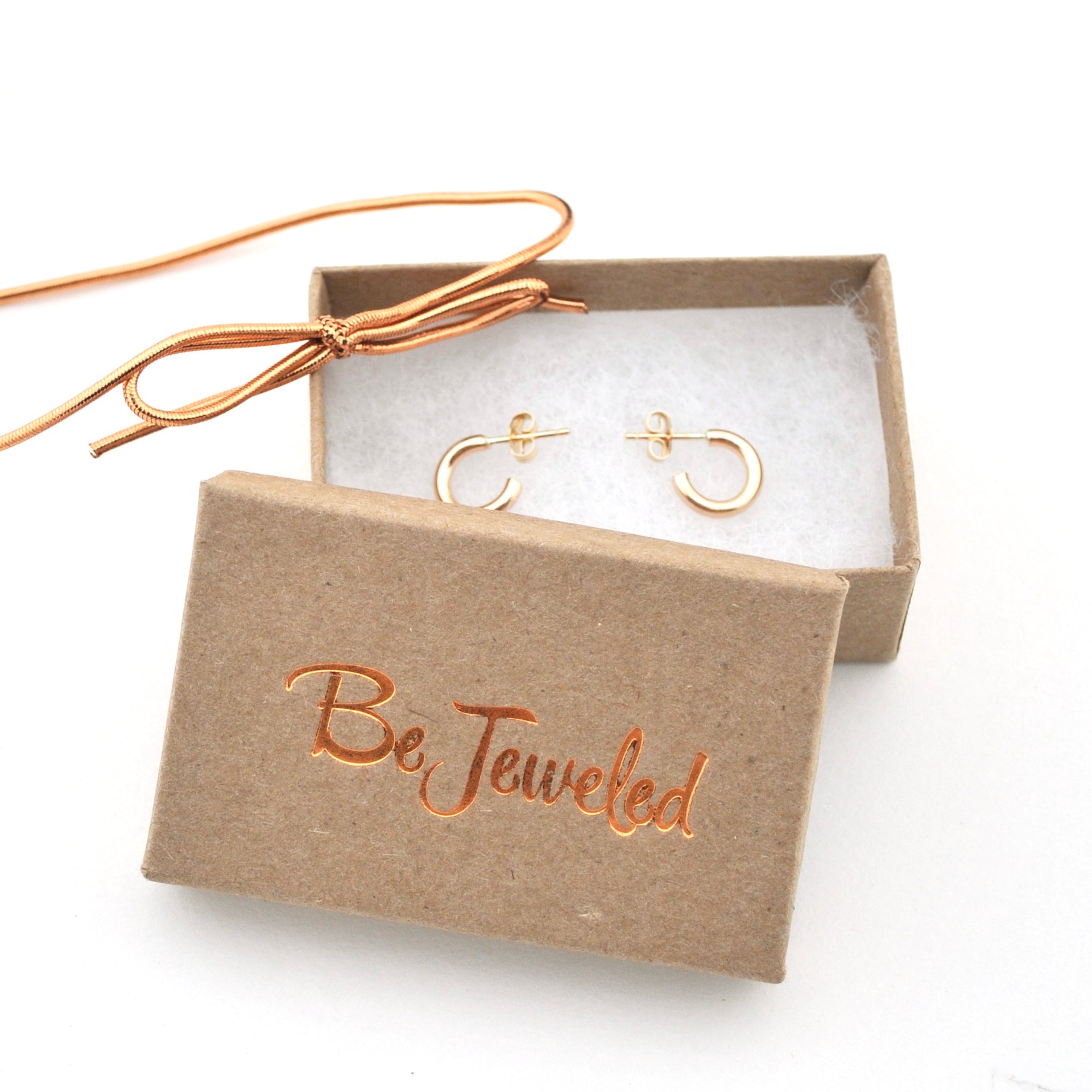 Gold necklace and earrings in a 'Be Jeweled' box on a white background