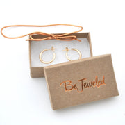 Gold hoop earrings in a 'Be Jeweled' box on a white background