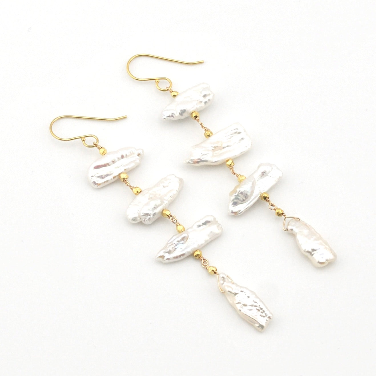 Pearl earrings with gold hooks on a white background