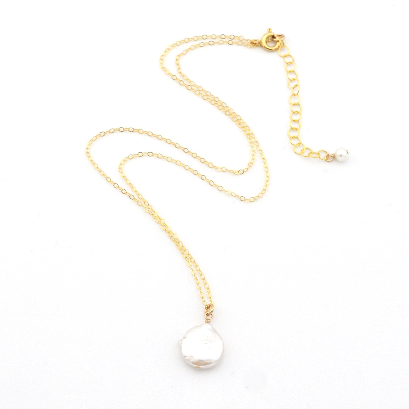 Gold necklace with a white pearl pendant on a white background