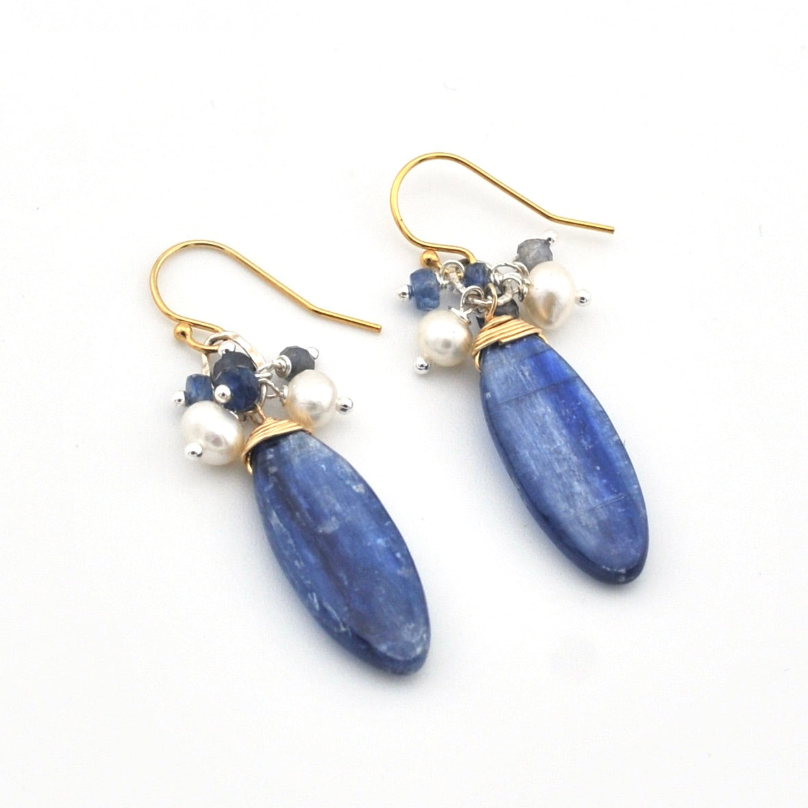 Blue teardrop earrings with gold and pearl accents on a white background