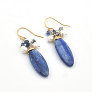 Blue teardrop earrings with gold and pearl accents on a white background