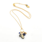 Gold necklace with gemstone pendants on a white background