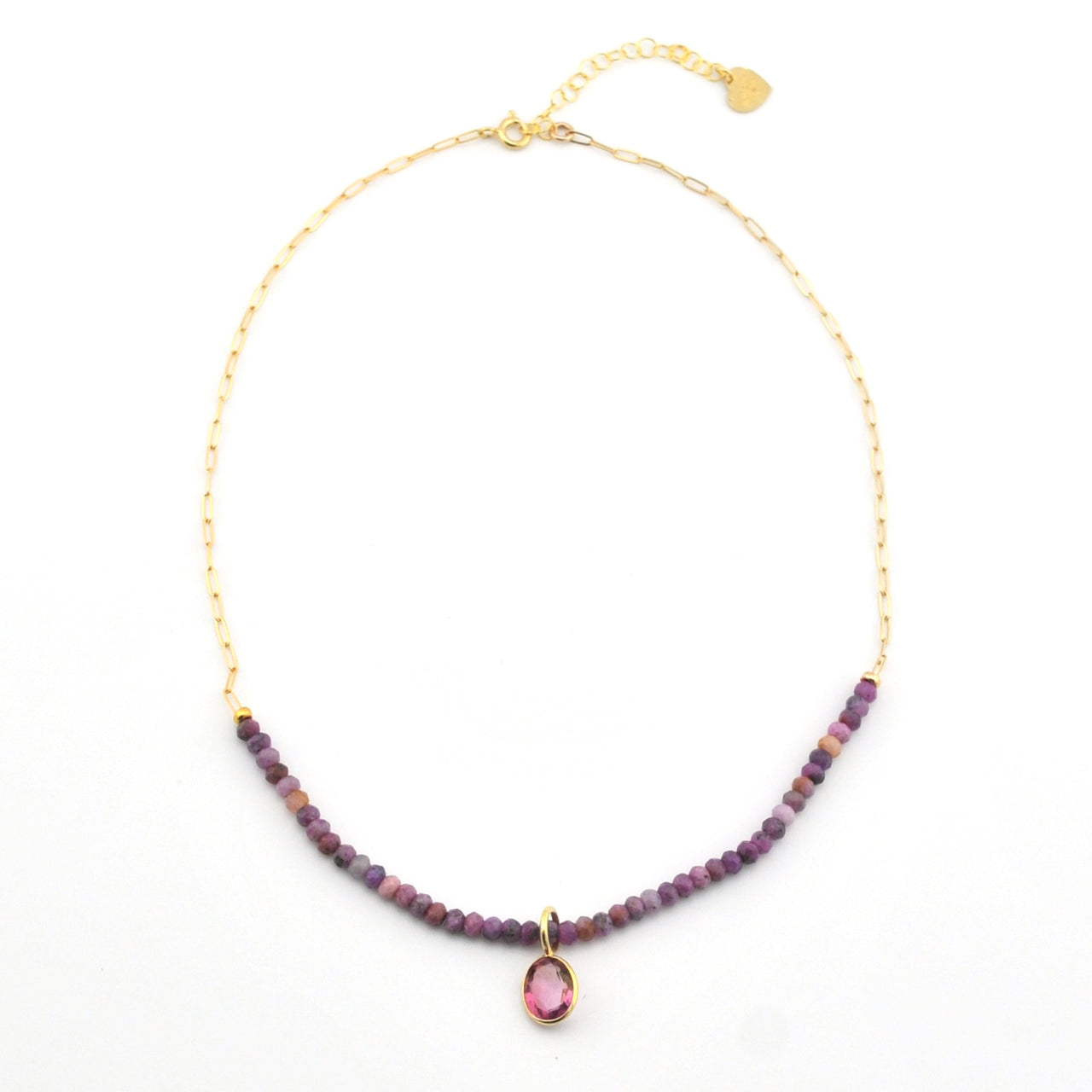 Necklace with purple beads and a pink gemstone pendant on a white background