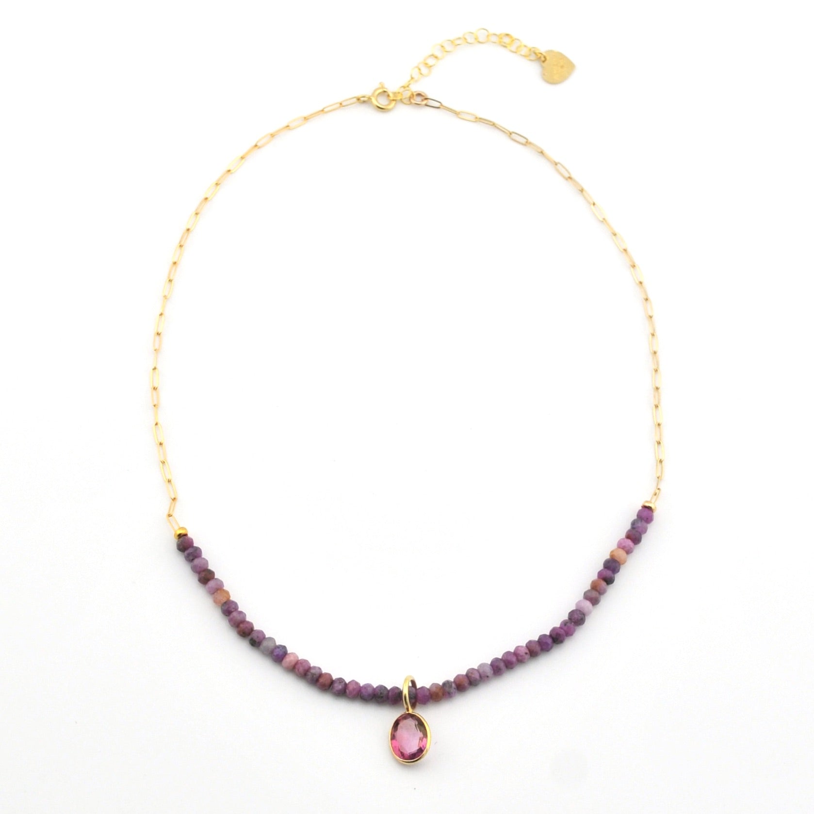 Necklace with purple beads and a pink gemstone pendant on a white background