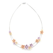 Wire necklace with purple, peach and gold flowers on white background.