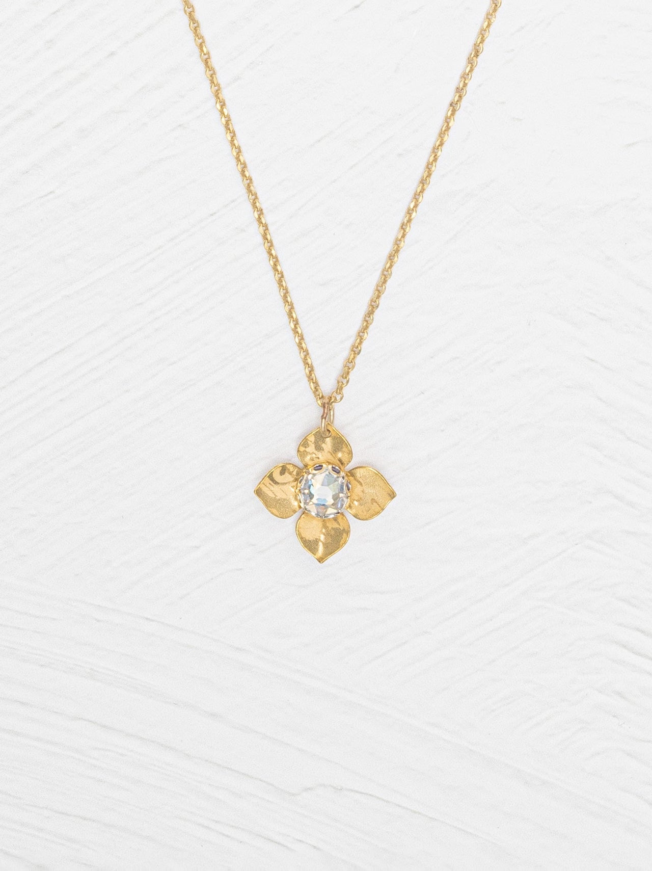 Gold necklace with a floral pendant on a white background