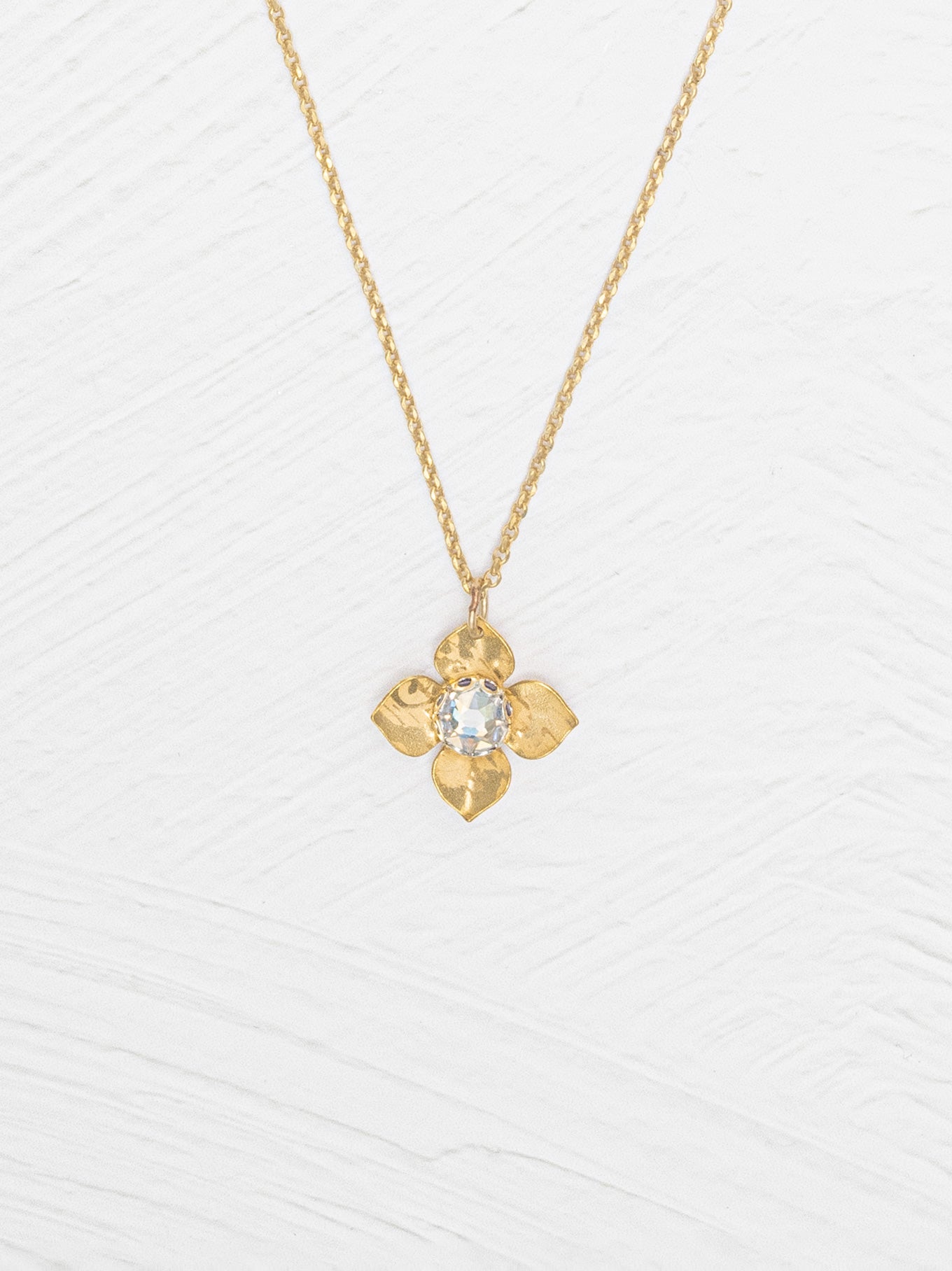 Gold necklace with a floral pendant on a white background