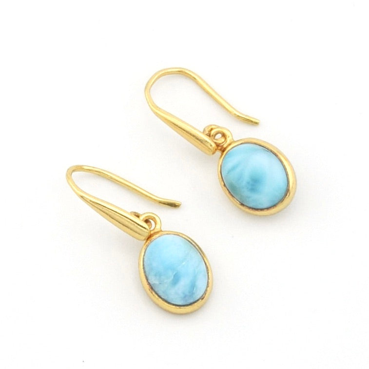 A pair of gold drop earrings with oval light blue marbled gemstones, set against a plain white background.