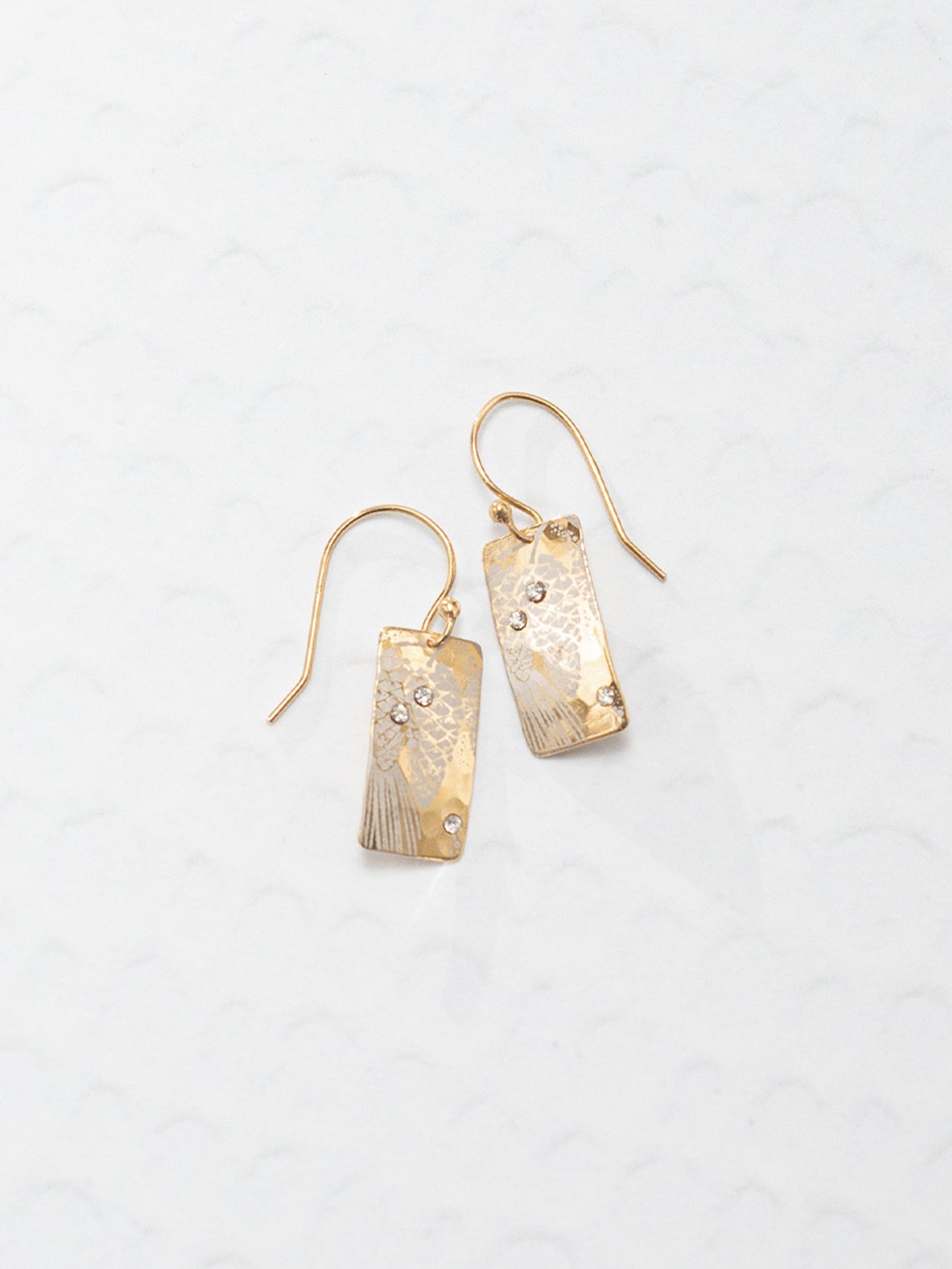 Pair of gold earrings on a light gray background