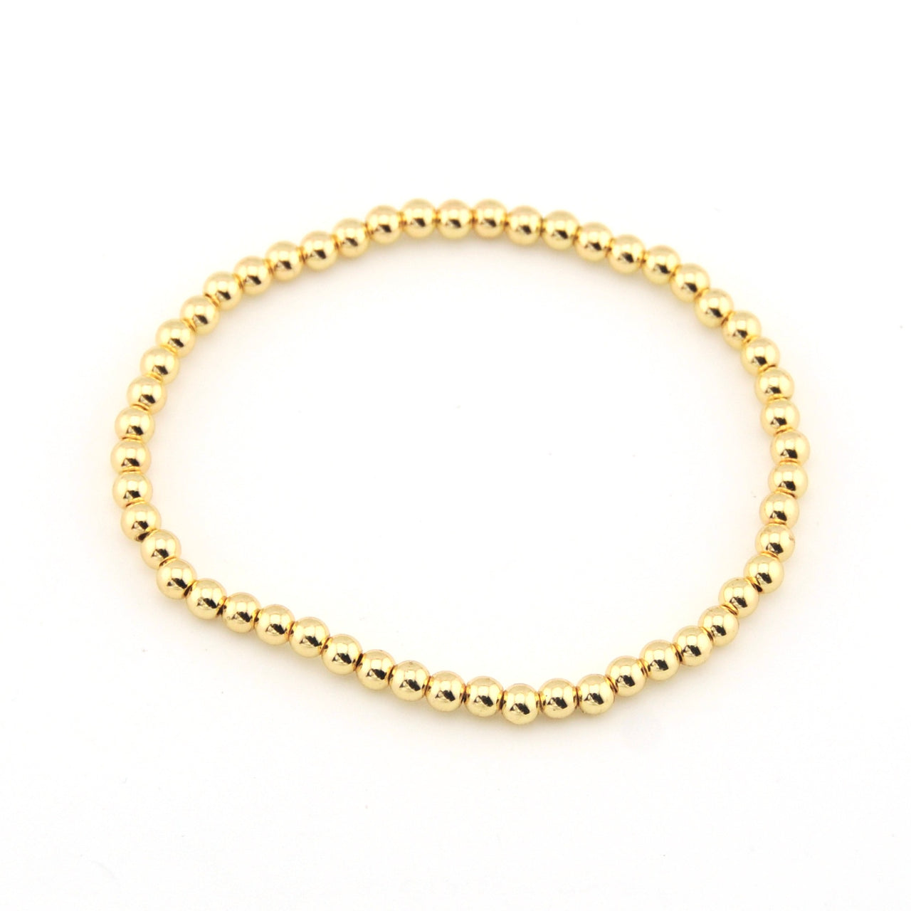 Gold beaded bracelet on a white background