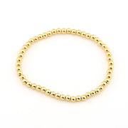 Gold beaded bracelet on a white background