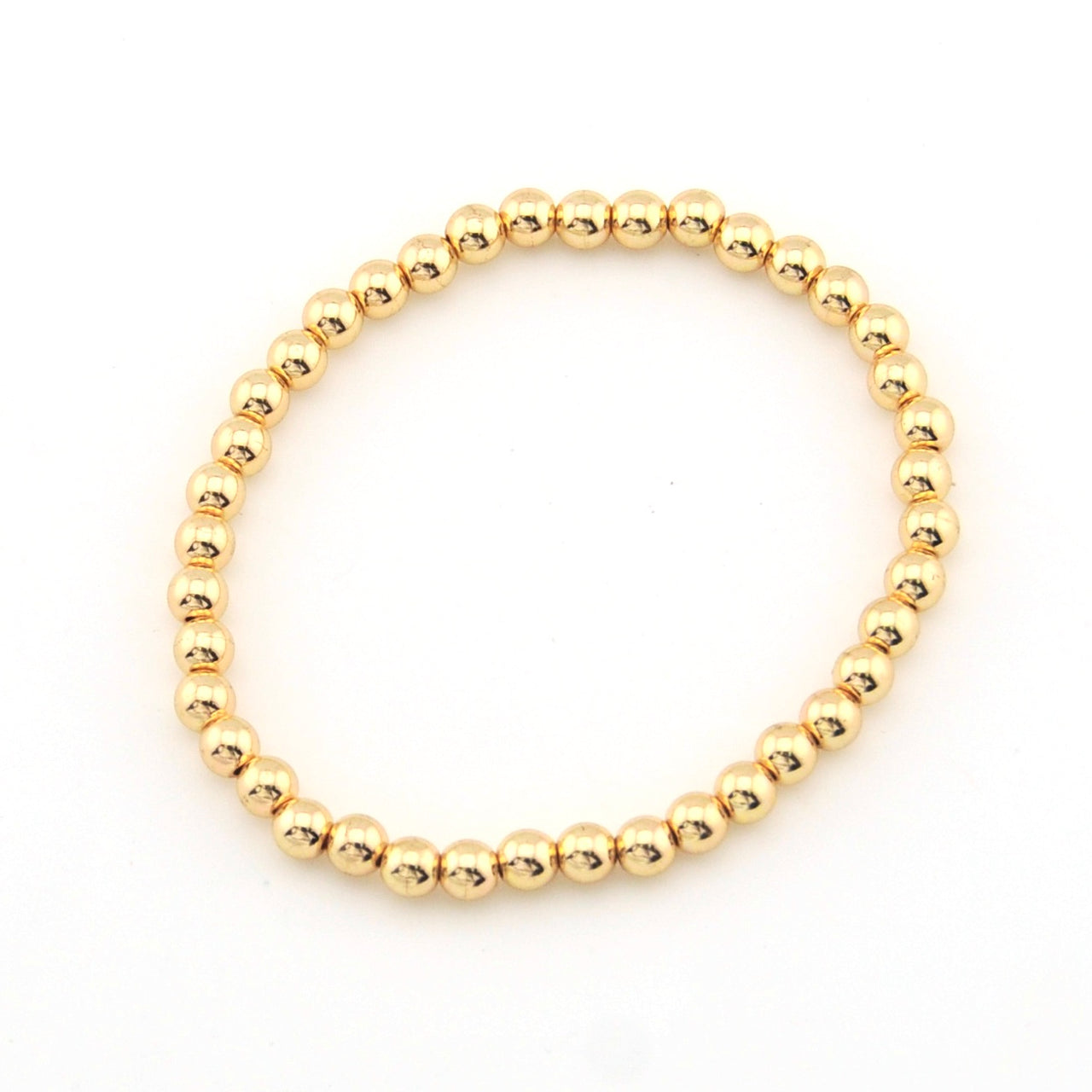 Gold beaded bracelet on a white background