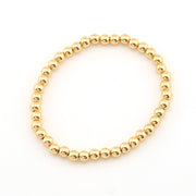 Gold beaded bracelet on a white background
