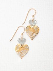 Heart-shaped earrings with gold, silver, and white floral patterns on a white background