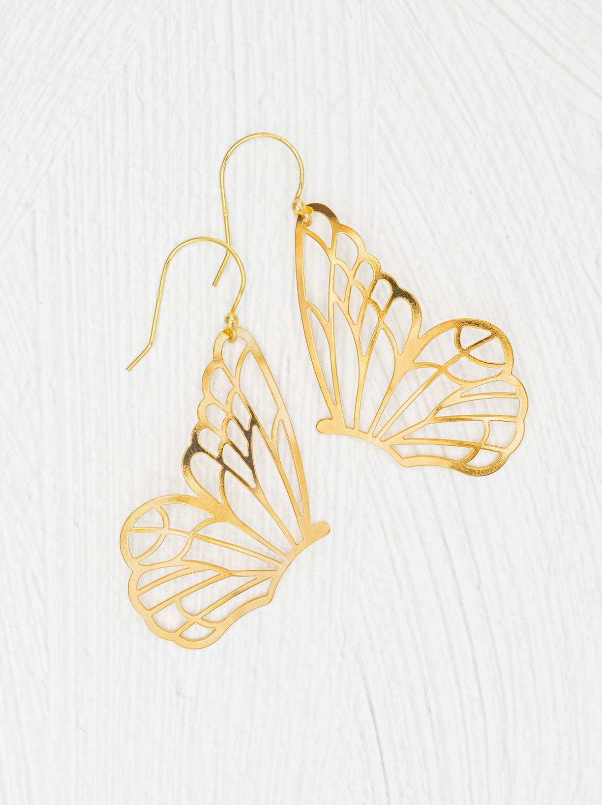 Gold butterfly-shaped earrings on a white background