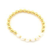 A beaded stretch bracelet featuring shiny gold metallic round beads and a section of irregular white baroque pearls, displayed on a clean white background.
