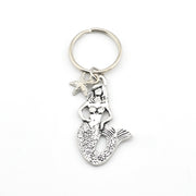 Silver mermaid keychain with starfish charm on a white background