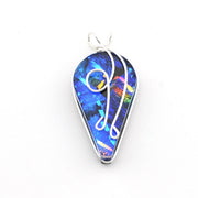 A teardrop-shaped pendant featuring a vibrant blue iridescent dichroic glass with silver wire art and a silver bezel, shown on a plain white background.