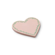 Heart-shaped pink ceramic plate with green floral patterns on a white background