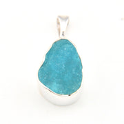 Hemimorphite pendant with silver setting on a white background