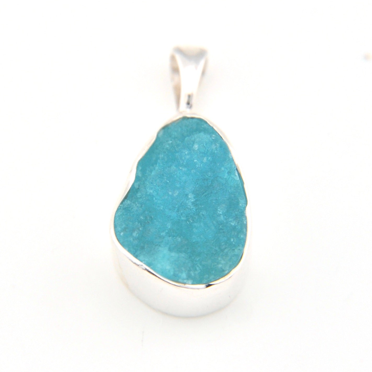 Hemimorphite pendant with silver setting on a white background