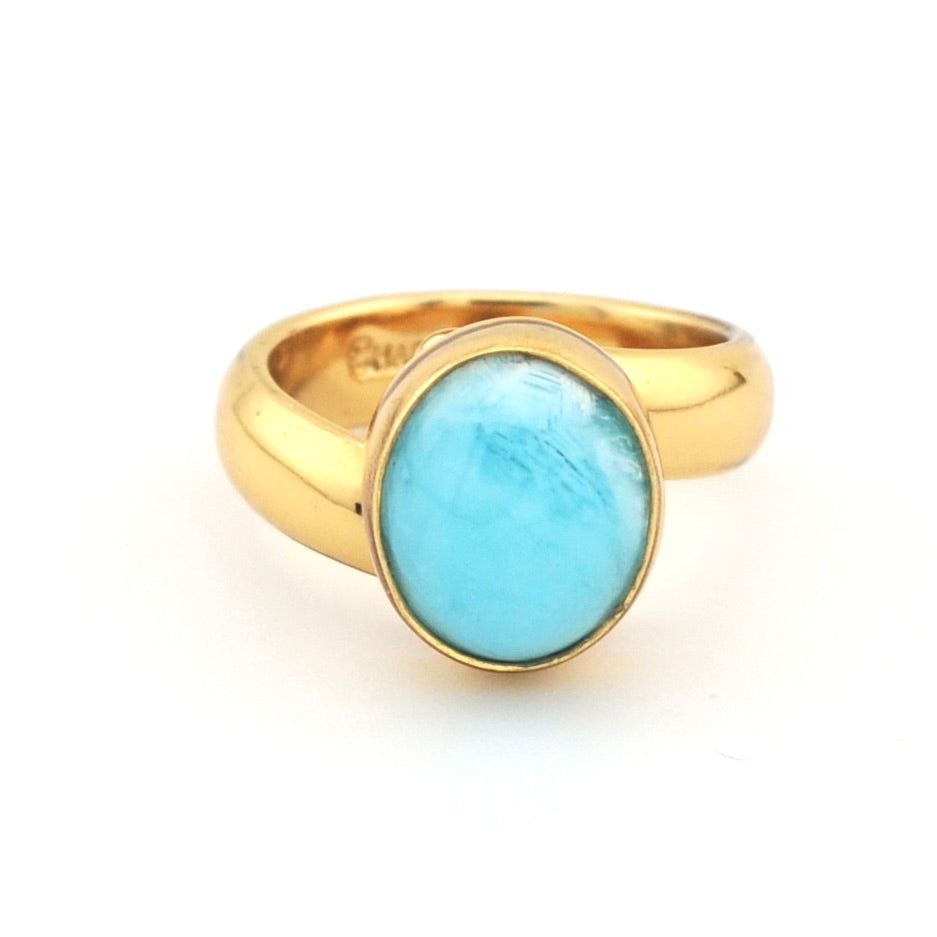 Gold ring with a blue stone on a white background