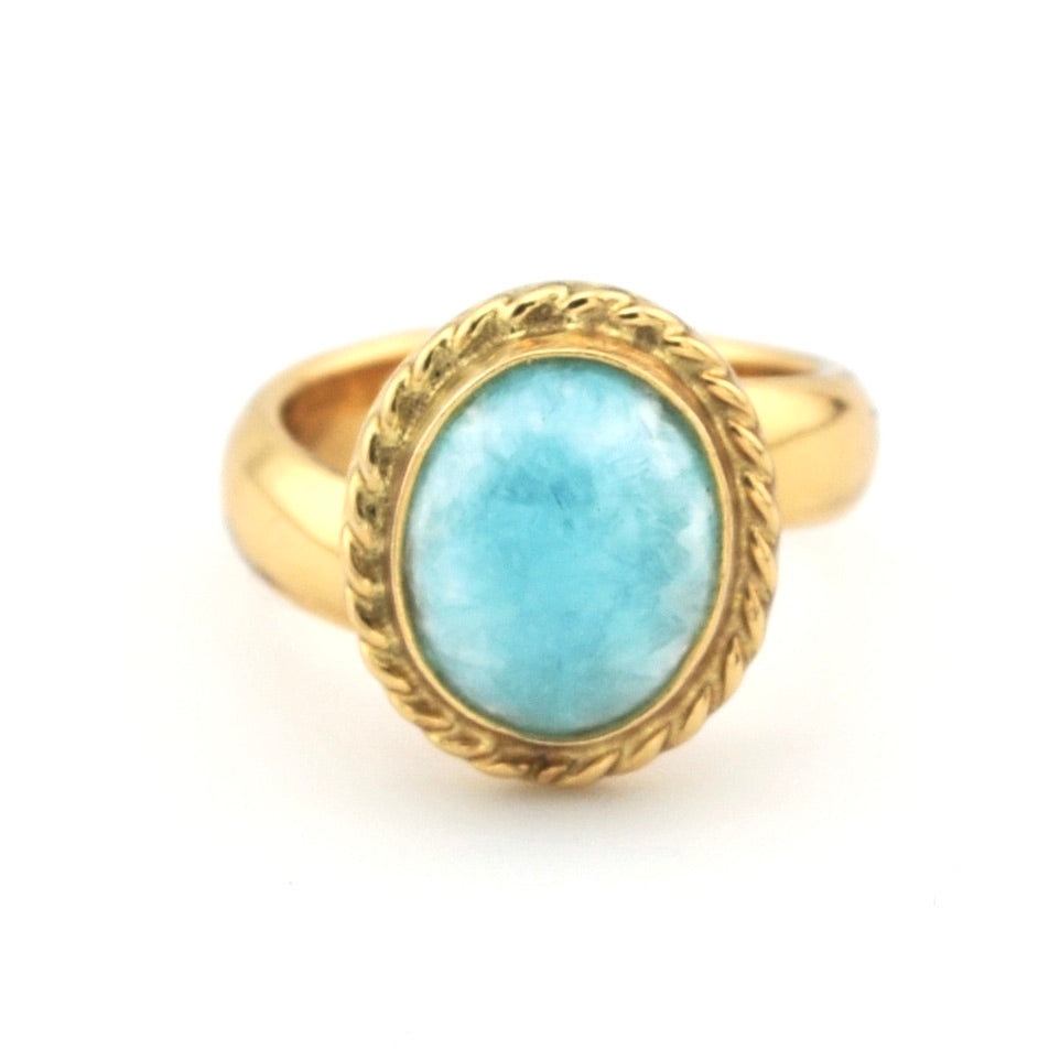 Gold ring with a blue stone on a white background