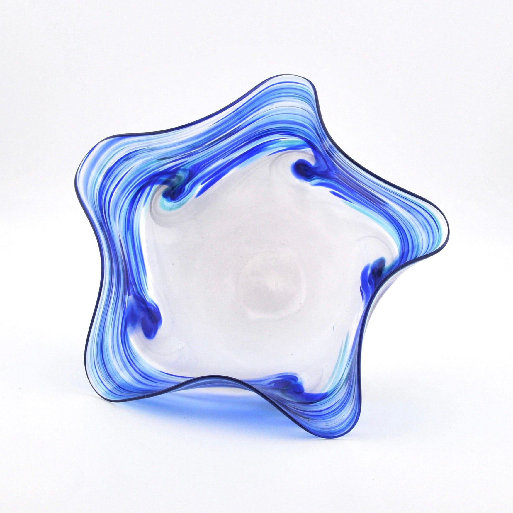Ruffled glass bowl with blue and white swirl design on a white background