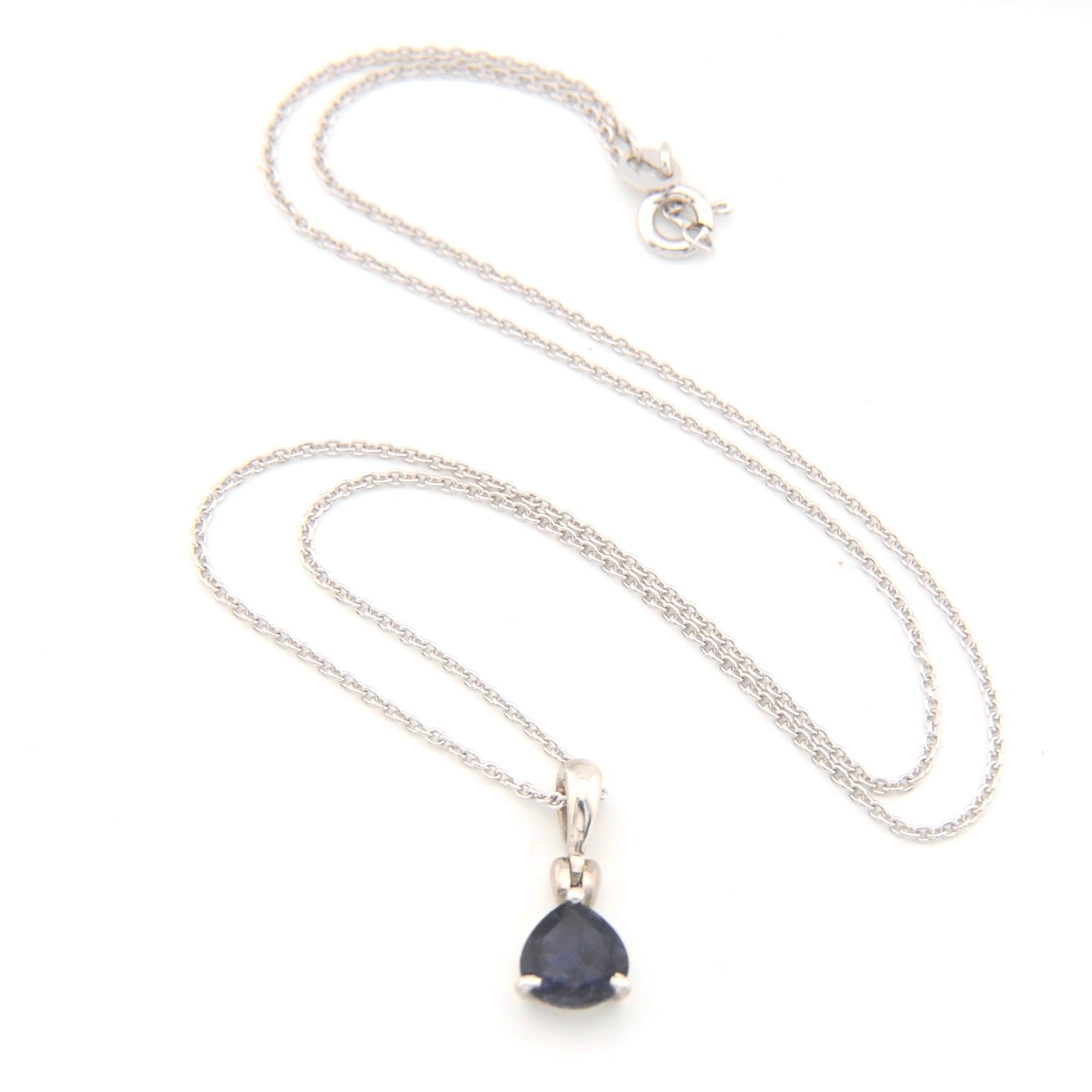 Silver necklace with a deep blue violet teardrop pendant on a white background