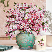 Bouquet of pink and white flowers in a decorative vase on a table.