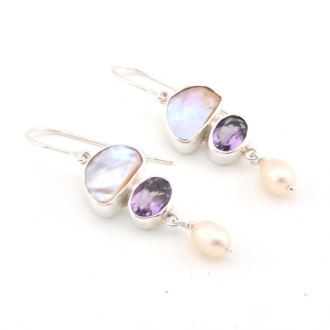 Pair of earrings with gemstones and pearls on a white background
