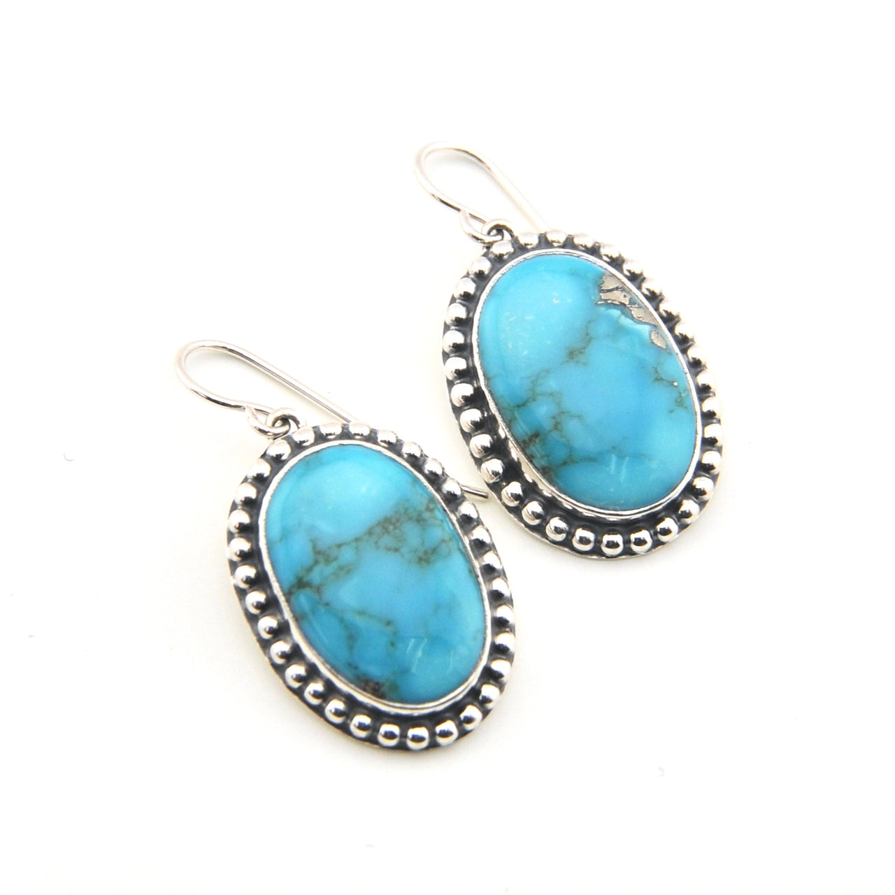 Turquoise earrings with silver frames on a white background