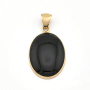 Black stone pendant with gold setting on a white background