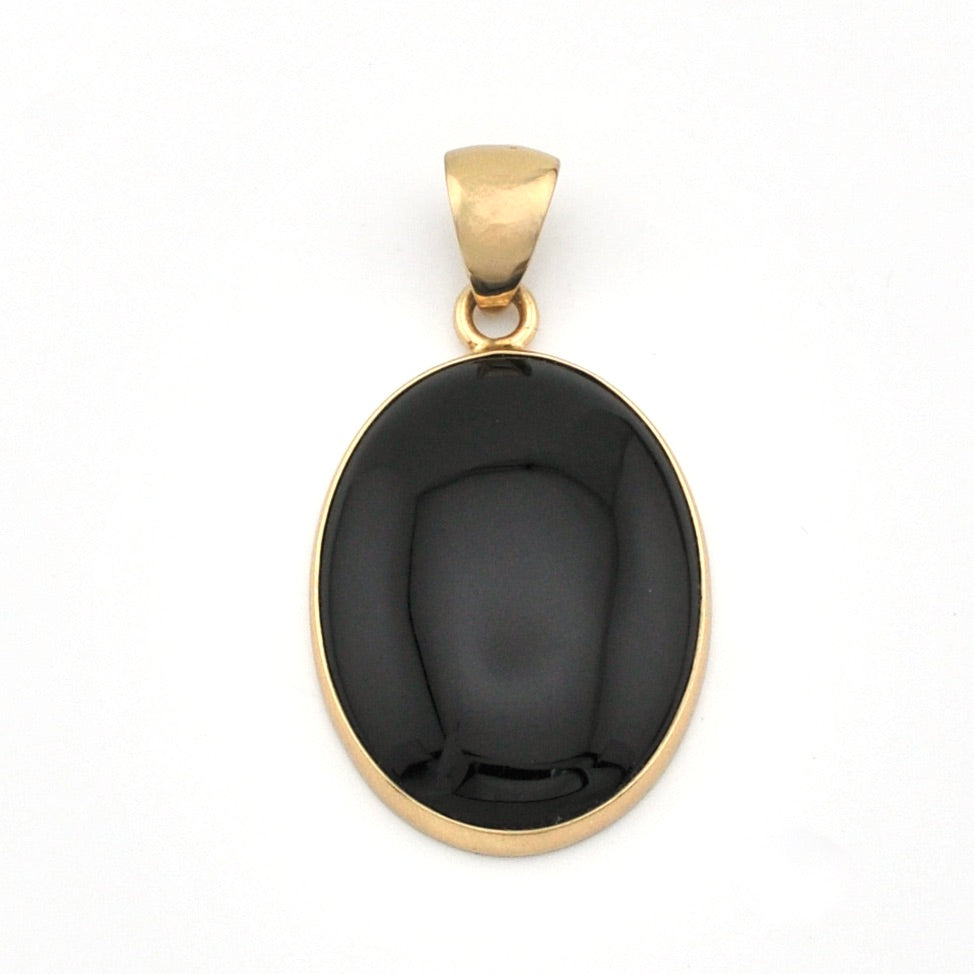 Black stone pendant with gold setting on a white background