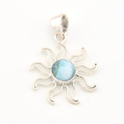 Silver sun-shaped pendant with a blue center on a white background