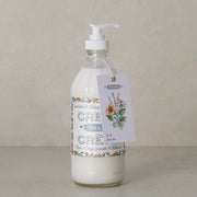 Bottle of Dot & Co. lotion with a floral label on a neutral background
