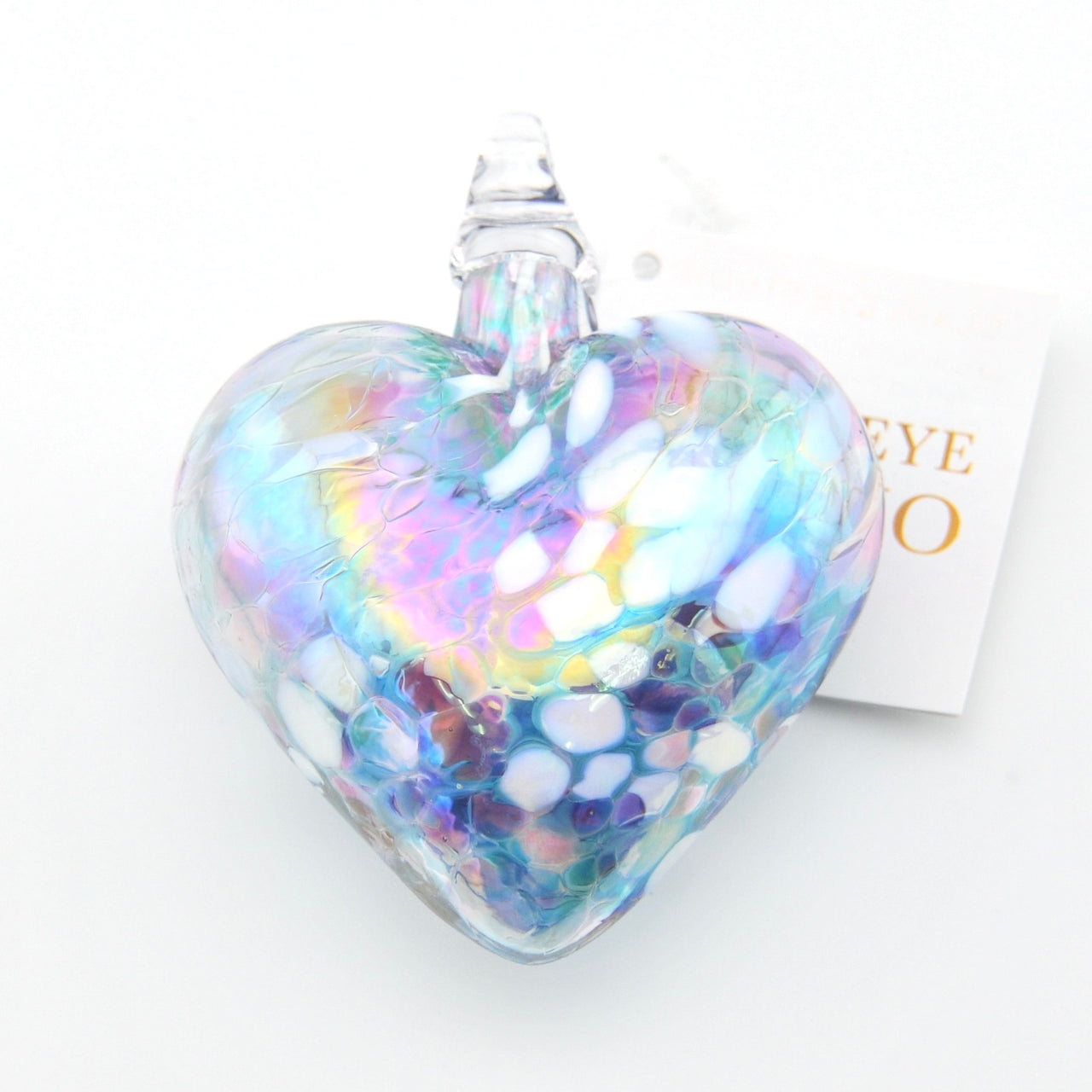 Heart-shaped glass ornament with iridescent finish on a white background