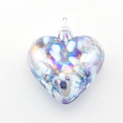 Heart-shaped glass ornament with iridescent colors on a white background