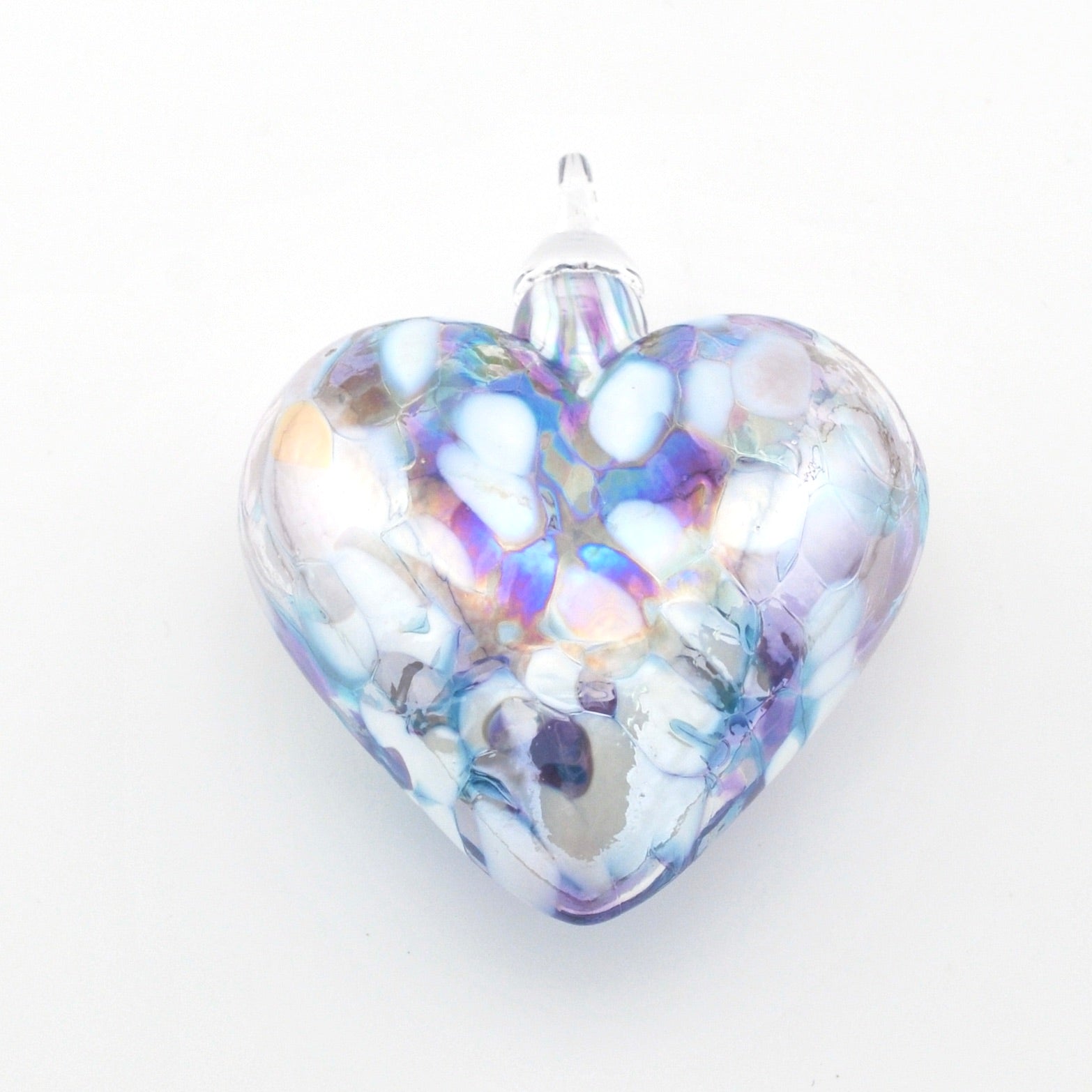 Heart-shaped glass ornament with iridescent colors on a white background