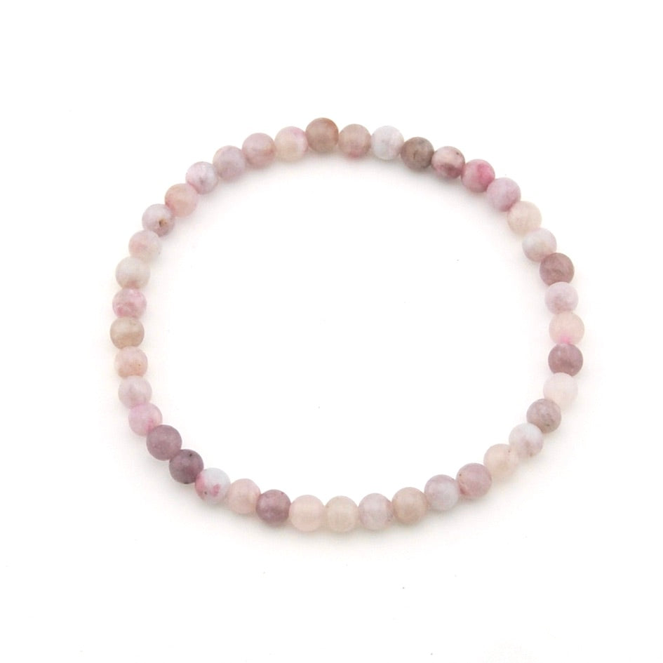 Round beaded bracelet with pink and white stones on a white background
