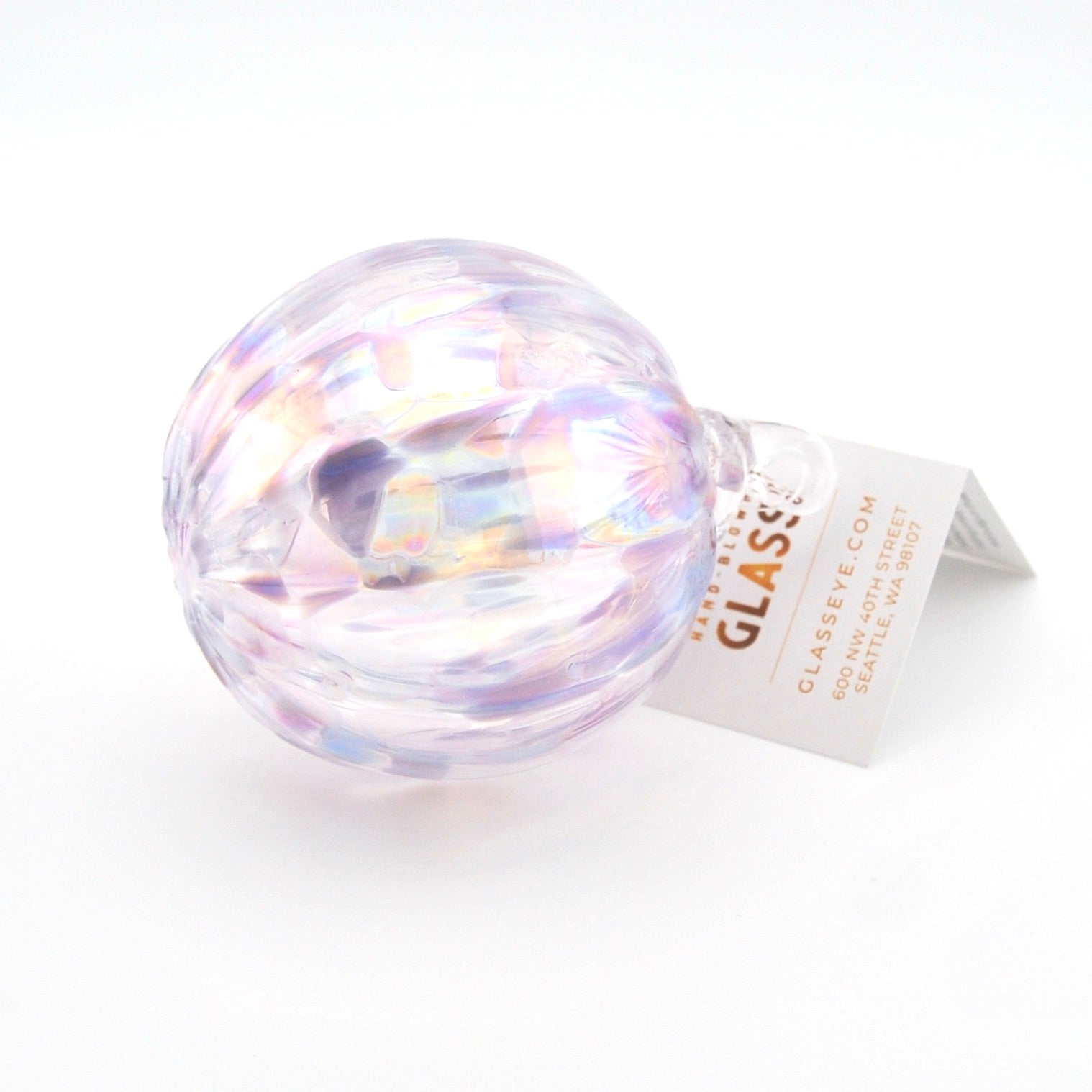 Iridescent glass ornament with a label on a white background