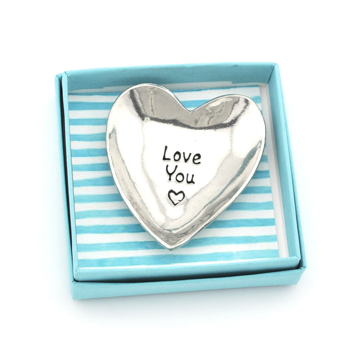 A polished silver heart-shaped dish engraved with 'Love You' and a small heart, presented inside a light blue gift box with a blue and white striped interior.