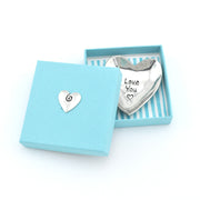 A silver heart-shaped dish or holder engraved with 'Love You' and a small heart, presented in a light blue gift box with a matching lid featuring a small heart emblem.