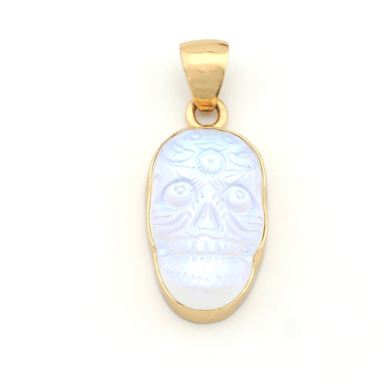 Gold pendant with a face design on a white background
