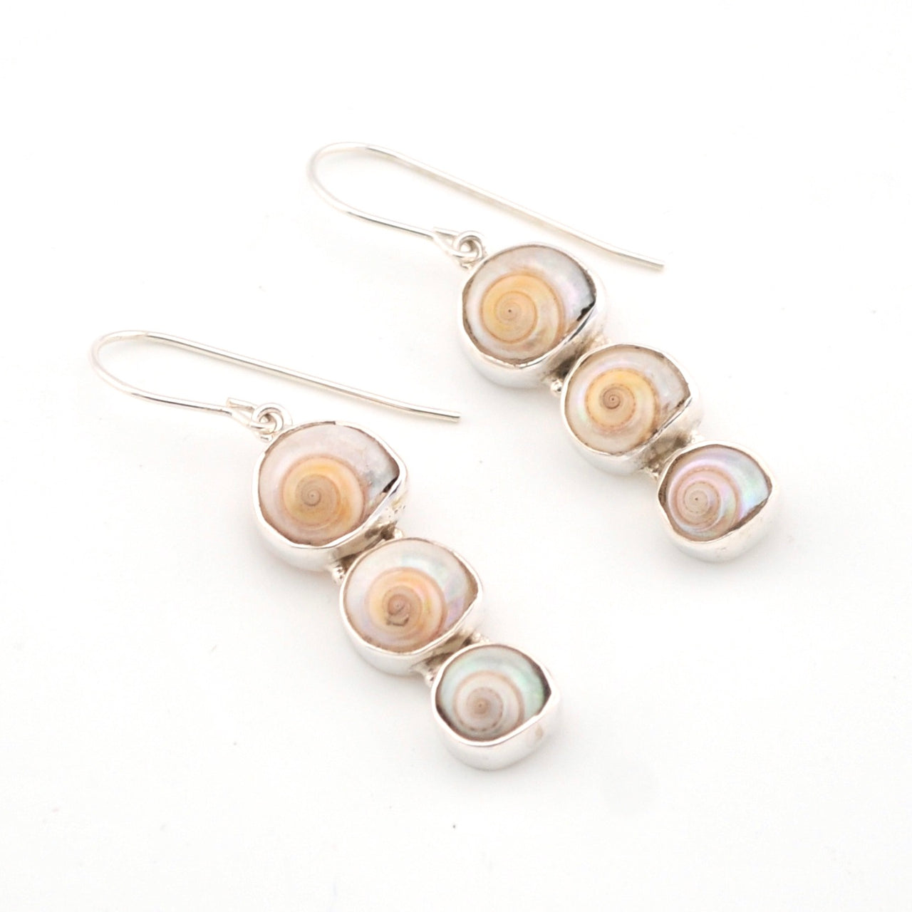 Pair of earrings with shell-like designs on a white background