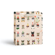 A small gift bag with a light beige background and an all-over print of illustrated cats in party hats and costumes. The bag has a silver glittery handle and is photographed on a clean white background.